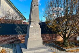 Plan moyen du monument aux morts. A droite on voit un arbre, au fond le toit d'une maison.