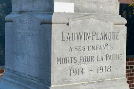 Photo en gros plan du socle du monument aux morts. On voit inscrit "Lauwin-Planque à ses enfants morts pour la patrie 1914 - 1918."