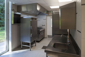 Photo des cuisines de la cantine scolaire. On voit différents meubles en ions et au premier plan un évier.